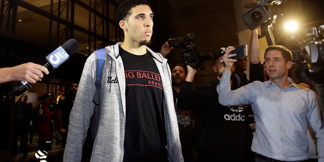 UCLA basketball player LiAngelo Ball is surrounded by reporters and photographers as he leaves Los Angeles International Airport on Tuesday, Nov. 14, 2017, in Los Angeles.