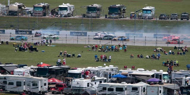 Fans watch a multi-car crash on the back straight during the Talladega 500 NASCAR Sprint Cup Series auto race at Talladega Superspeedway, Sunday, May 3, 2015, in Talladega, Ala. (AP Photo/Butch Dill)