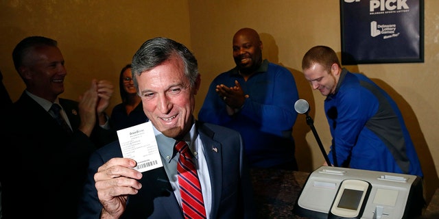 Delaware Gov. John Carney displays a receipt for a bet he placed on a baseball game between the Chicago Cubs and the Philadelphia Phillies inside the Race and Sports Book at Dover Downs Hotel and Casino.