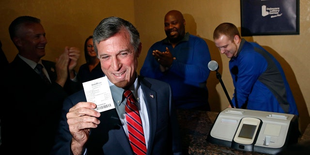 Delaware Gov. John Carney displays a receipt for a bet he placed on a baseball game between the Chicago Cubs and the Philadelphia Phillies inside the Race and Sports Book at Dover Downs Hotel and Casino.