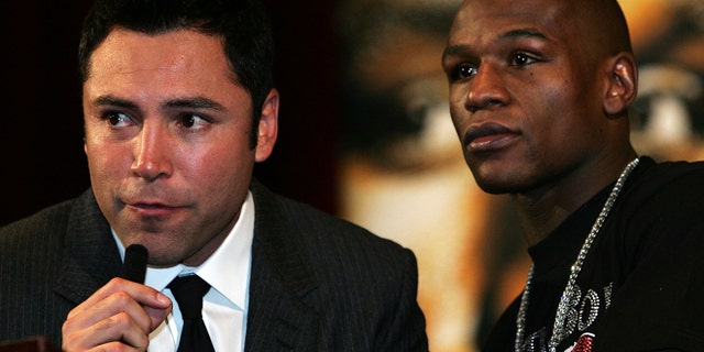 Promoter Oscar De La Hoya speaks alongside Floyd Mayweather Jr. (Photo by John Gichigi/Getty Images)