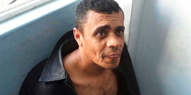 In this photo released by the Military Police, Adelio Bispo de Oliveira, suspected of stabbing Bolsonaro sits after being detained in Juiz de Fora, Brazil on Thursday.