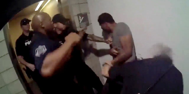 This May 23, 2018 still file image taken from a body camera video and released by the Mesa Police Department shows police officers approaching a man in Mesa, Ariz.