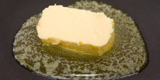 Piece of butter melting on non-stick frying pan