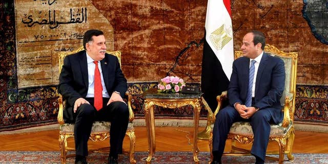 In this photo released by the Egyptian Presidency, Libyan Prime Minister Fayez al-Serraj, left, meets with Egyptian President Abdel-Fattah el-Sissi in Cairo, Egypt, Sunday, May 8, 2016. Libya's new prime minister called on the international community to help the country bolster its fight against terrorism on Sunday, urging the lifting an arms embargo and release of funds that remain frozen under U.N. sanctions. (Egyptian Presidency via AP)