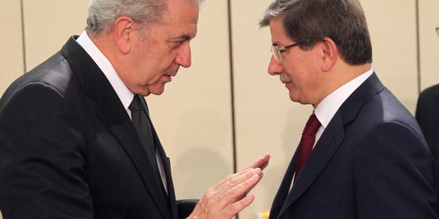 Greek Foreign Minister Dimitrios Avramopoulos, left, talks with Turkish counterpart Ahmet Davutoglu, during a NATO foreign ministers meeting at NATO headquarters in Brussels, Tuesday, April 23, 2013. NATO foreign ministers meet in Brussels to discuss the situation in Syria and Afghanistan. (AP Photo/Yves Logghe)