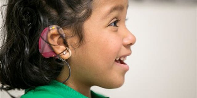 In this photo taken Feb. 11, 2015, Angelica Lopez, 3, smiles during a therapy session at the University of Southern California in Los Angeles. (AP Photo/Damian Dovarganes)