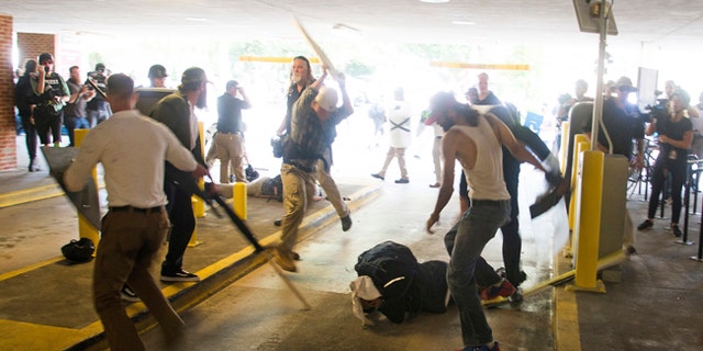 Deandre Harris, bottom, is assaulted in a parking garage beside the Charlottesville Police Station after a white nationalist rally in Charlottesville, Va.