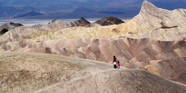 In this April 11,2010 file photo, tourists walk along a ridge at Death Valley National Park, Calif.