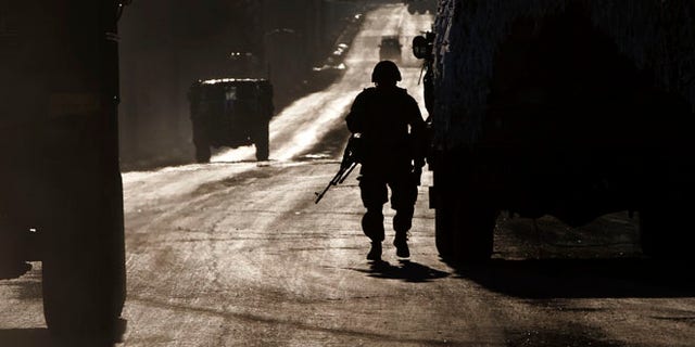 Feb. 18, 2015: An Ukrainian soldier stands next to a broken down vehicle outside Artemivsk, Ukraine, as troops pull out of Debaltseve,