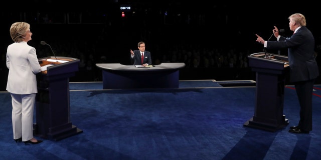 Democratic presidential nominee Hillary Clinton listens as Republican presidential nominee Donald Trump answers a question during the third presidential debate at UNLV in Las Vegas, Wednesday, Oct. 19, 2016. (Joe Raedle/Pool via AP)