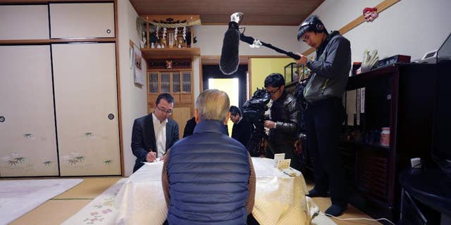 Shoichi Yukawa, center, father of Haruna Yukawa, one of two Japanese hostages held by the Islamic State group, speaks during an interview at his house in Chiba, near Tokyo Sunday, Jan. 25, 2015. Japanese officials are working to verifying a new message purported to be from the Islamic State group holding the hostages. The Associated Press could not verify the contents of the message, which varied greatly from previous videos released by the Islamic State group, which now holds a third of both Syria and Iraq. (AP Photo/Asahi Shimbun, Yasuhiro Sugimoto, Pool)