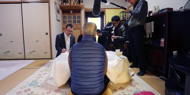 Shoichi Yukawa, center, father of Haruna Yukawa, one of two Japanese hostages held by the Islamic State group, speaks during an interview at his house in Chiba, near Tokyo Sunday, Jan. 25, 2015. Japanese officials are working to verifying a new message purported to be from the Islamic State group holding the hostages. The Associated Press could not verify the contents of the message, which varied greatly from previous videos released by the Islamic State group, which now holds a third of both Syria and Iraq. (AP Photo/Asahi Shimbun, Yasuhiro Sugimoto, Pool)