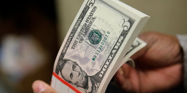 March 26, 2015: A packet of former U.S. President Abraham Lincoln five-dollar bill currency is inspected at the Bureau of Engraving and Printing in Washington.