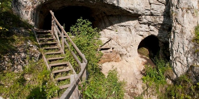 The existence of this archaic human group came to light in 2010 when DNA from a piece of a finger bone and two molars that were excavated at Denisova Cave in the Altai Mountains of southern Siberia was studied. Shown here, the entrance to the c