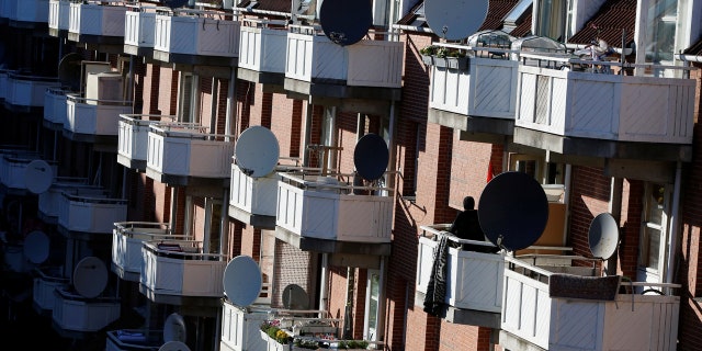 A woman stands on a terrace in Mjolnerparken, a housing estate that features on the Danish government's "Ghetto List", in Copenhagen, Denmark, May 8, 2018.