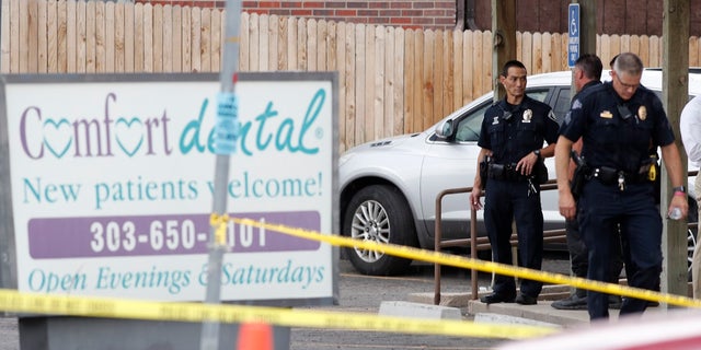 Law enforcement officials investigate the scene of a shooting in a parking lot behind a Colorado dentist's office on Thursday, June 14, 2018.