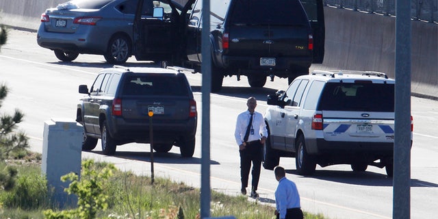 June 1, 2018: Denver Police Department detectives, foreground, investigate near where a Nissan sedan, top left, being driven by an Uber driver crashed into a retaining wall along Interstate 25 south of downtown Denver.