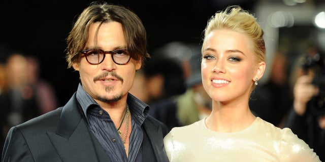 Johnny Depp and Amber Heard pose for photographers as they arrive for the European premiere of 'The Rum Diary', London, November 3, 2011. REUTERS/Paul Hackett (BRITAIN - Tags: ENTERTAINMENT PROFILE SOCIETY) - RTR2TKVR
