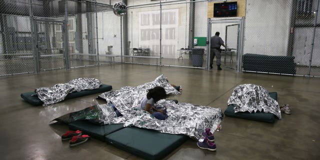 MCALLEN, TX - SEPTEMBER 08: A girl from Central America rests on thermal blankets at a detention facility run by the U.S. Border Patrol on September 8, 2014 in McAllen, Texas. The Border Patrol opened the holding center to temporarily house the children after tens of thousands of families and unaccompanied minors from Central America crossed the border illegally into the United States during the spring and summer. Although the flow of underage immigrants has since slowed greatly, thousands of them are now housed in centers around the United States as immigration courts process their cases. (Photo by John Moore/Getty Images)