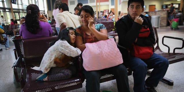 A Guatemalan family waits at the Greyhound bus station before their trip to Maryland on July 25, 2014 in McAllen, Texas.