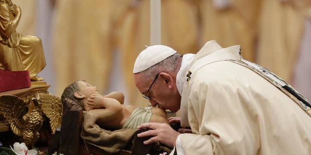 Pope Francis kisses a statue of the Divine Infant as he celebrates an Epiphany Mass in St. Peter's Basilica at the Vatican, Friday, Jan. 6, 2017. (AP Photo/Andrew Medichini)