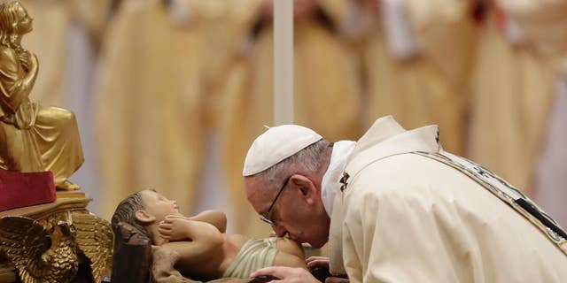 Pope Francis kisses a statue of the Divine Infant as he celebrates an Epiphany Mass in St. Peter's Basilica at the Vatican, Friday, Jan. 6, 2017. (AP Photo/Andrew Medichini)