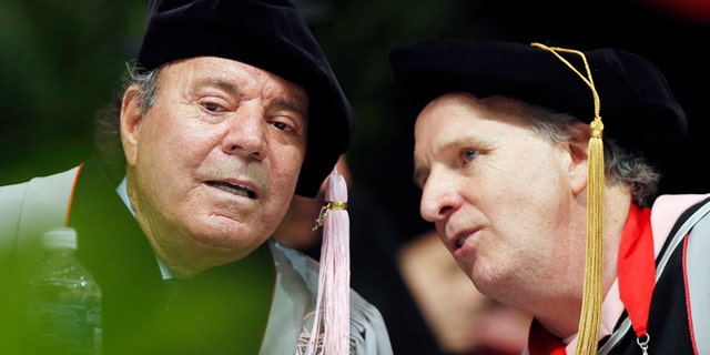 Julio Iglesias, left, speaks with Berklee College of Music president Roger Brown before receiving an honorary doctor of music degree during commencement ceremonies, Saturday, May 9, 2015, in Boston. (AP Photo/Michael Dwyer)