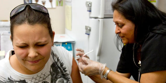 Stephanie Dugger, 20, of Apache Junction, gets a flu shot from nurse Bhagwati Bhakta at Mollen Immunization Clinics in Scottsdale, Ariz. Thursday, Jan. 10, 2013. Arizona health officials say flu activity is widespread in the state this week with influenza reported in 14 of its 15 counties. (AP Photo/The Arizona Republic, Cheryl Evans)  MARICOPA COUNTY OUT; MAGS OUT; NO SALES