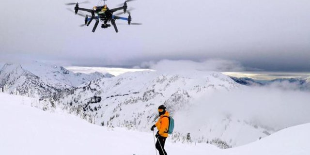 A drone camera hovering by a skier as he makes his way down mountainside at resort at Revelstoke, B.C., Canada in Dec. 2014.
