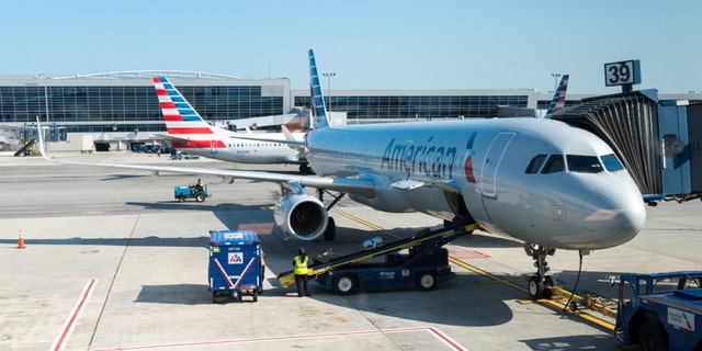 New York, USA - July 10, 2015: An America Airlines plane sitting at gate 39 at JFK airport late in the day as ground crew finish up before take off.