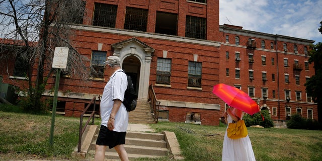 FILE: Visitors view the abandoned buildings on the grounds of the east campus of the historic St. Elizabeth's Hospital in Washington.