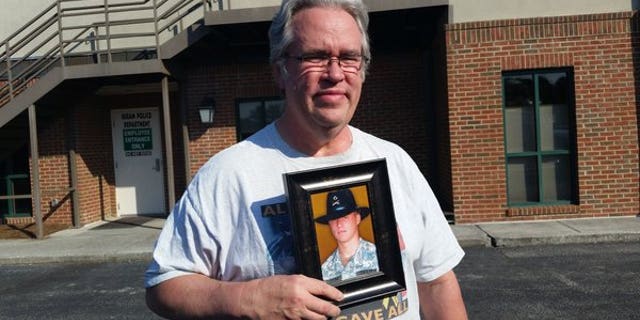 Tommy Dingler is seen holding a photo of his son, Joshua, who was 19 years old when he died while serving in Iraq.