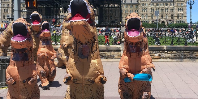Mom dresses up as a dinosaur to make her daughter laugh before first day of kindergarten.