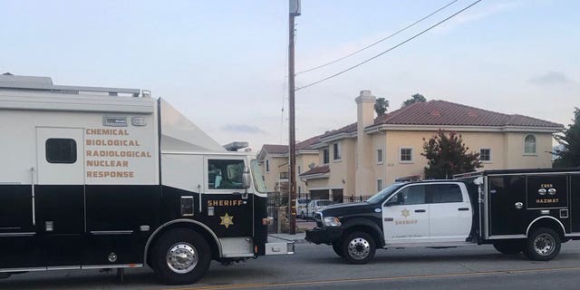 El Monte police vehicles are seen near the site where an unknown suspect doused a woman with a "caustic chemical."