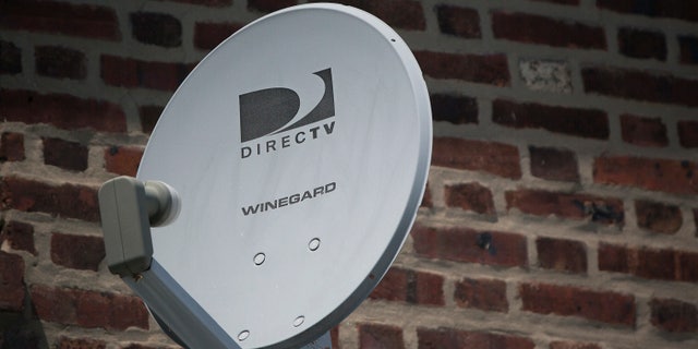 A Direct TV dish is seen outside a home in the Queens borough of New York July 29, 2013. Satellite TV provider DirecTV reported August 1, 2013 that it missed second-quarter earnings estimates as it lost more customers than expected in the United States and added fewer than expected in its Latin American unit. REUTERS/Shannon Stapleton (UNITED STATES - Tags: BUSINESS) - RTX126Z1