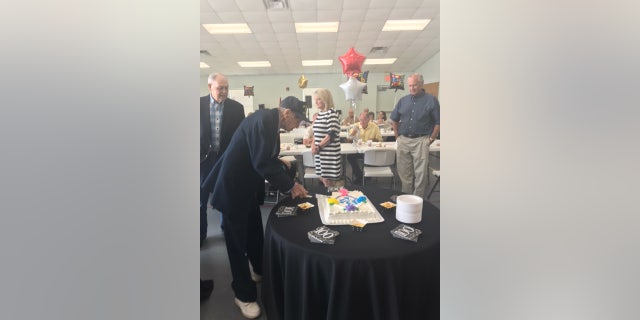 Dixon cuts a cake during his 100th birthday celebration at the North Carolina church.