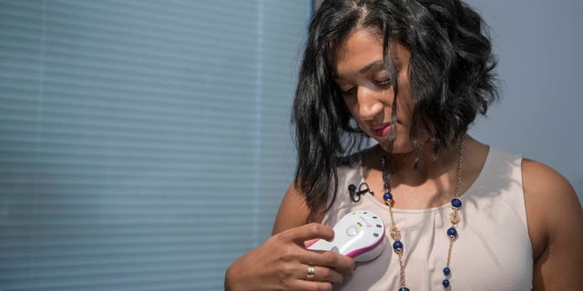 In this Thursday, Oct. 20, 2016, photo, Luincys Fernandez demonstrates how she had used the AeroForm handheld dosage controller during an interview at NewYork-Presbyterian/Columbia University Medical Center.