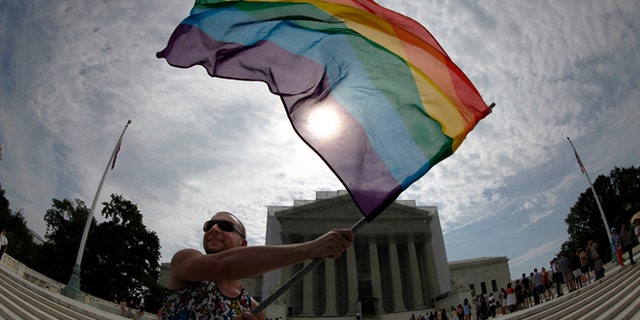 A gay marriage supporter waves a rainbow flag outside the U.S. Supreme Court in Washington on June 24, 2013. (Reuters)