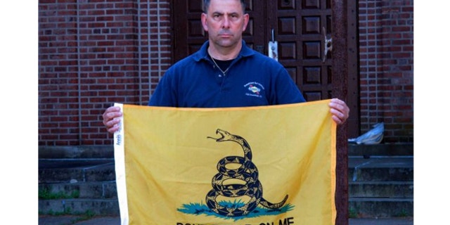 April 26, 2013: Peter Parente, president of the United Veterans Memorial and Patriotic Association, holds a Gadsden flag outside an armory in New Rochelle, N.Y.