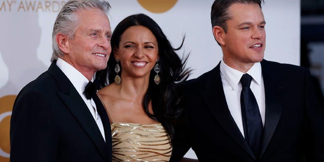 Actor Michael Douglas from HBO's movie "Behind the Candelabra" arrives with co-star Matt Damon and his wife, Luciana Barroso, at the 65th Primetime Emmy Awards in Los Angeles September 22, 2013. REUTERS/Mario Anzuoni (UNITED STATES Tags: ENTERTAINMENT) (EMMYS-ARRIVALS) - RTX13VT2