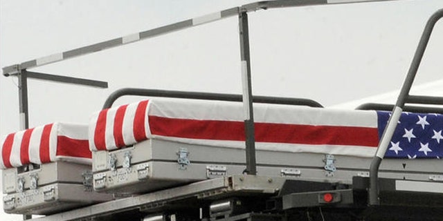 Transfer cases containing the remains of Pfc. Joshua L. Jetton, left case, and Sgt. James W. Harvey II, right case, sit on a loader during a prayer Wednesday, June 22, 2011 at Dover Air Force Base, Del. According to the Department of Defense, Jetton, of Sebring, Fla., died while supporting Operation Enduring Freedom and Harvey, 23, of Toms River, N.J., died June 20 in Ghazni province, Afghanistan of wounds sustained when insurgents attacked his unit with small arms fire. (AP Photo/Steve Ruark)