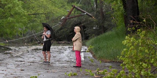Two women look at the storm damage in Bridgewater, Conn., on Tuesday after severe storms rolled through the area.