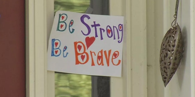 Signs of support hang for 15-year-old David Albright, who is in critical condition after was swept through an underground drainage pipe.