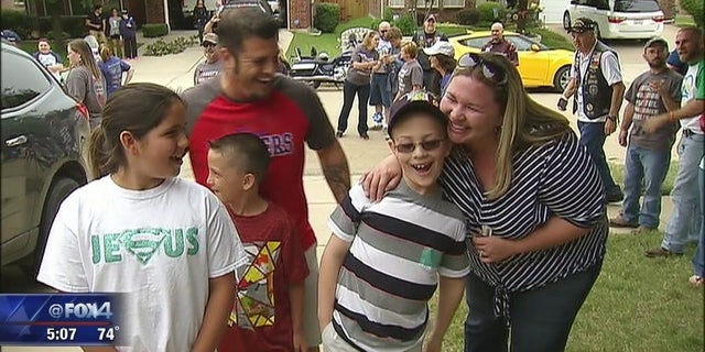 Bryce Aswell, center, arrives at his home to see his new room with his family.