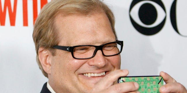 Actor and comedian Drew Carey takes a photo with his mobile phone at a CBS, CW, CBS Television Studios and Showtime party for the Television Critics Association Cable summer press tour at the Huntington Library in San Marino, California August 3, 2009. REUTERS/Mario Anzuoni (UNITED STATES ENTERTAINMENT) - RTR26E1R