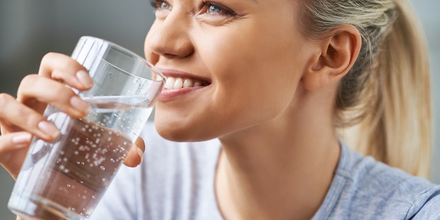 Beautiful young woman drinking water