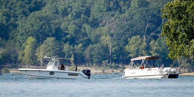 Emergency workers patrol an area on Friday near where a duck boat capsized the night