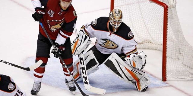 Anaheim Ducks goalie Jonathan Bernier (1) reaches out to make a save on a shot as Arizona Coyotes left wing Jamie McGinn (88) looks for a possible rebound during the third period of an NHL hockey game Saturday, Jan. 14, 2017, in Glendale, Ariz. The Ducks defeated the Coyotes 3-0. (AP Photo/Ross D. Franklin)