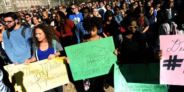 April 1, 2015: Duke student from front left to right, Michaela Stith, Ashley Croker-Benn and Jasmine Roddey rally during a university-wide forum outside the Duke Chapel on campus.